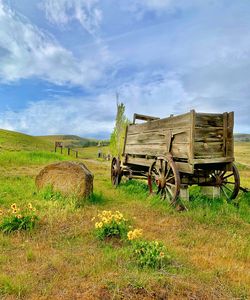 Hay bales on field against sky