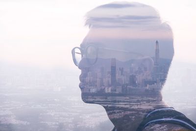 Digital composite image of man using mobile phone in city