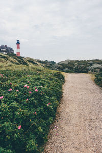 Pathway leading to lighthouse against the sky