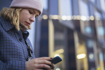 Young woman using phone outdoors