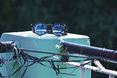 Close-up of sunglasses against blue sky