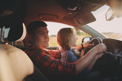 Rear view of people sitting in car