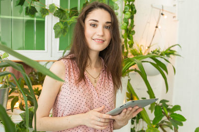 Portrait of young woman using mobile phone outdoors