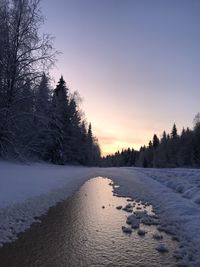 Scenic view of snow covered field against sky during sunset