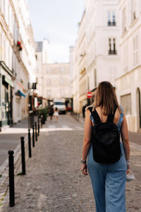 Rear view of woman walking on street in city