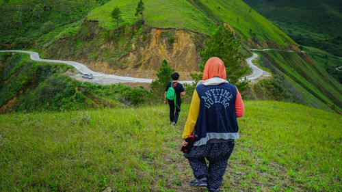 Rear view of men walking on farm