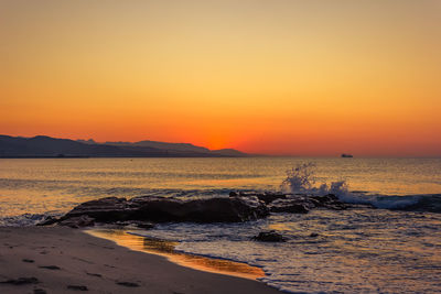 Scenic view of sea against orange sky