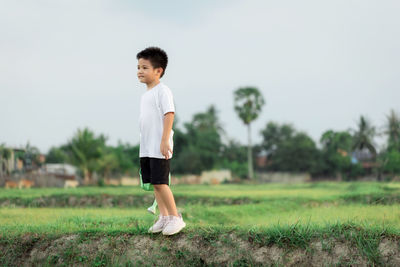 Full length of boy on field against sky