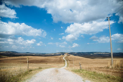 Rear view of person walking on country road