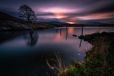 Scenic view of lake against sky at sunset