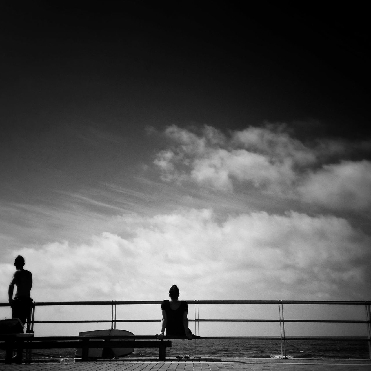 railing, silhouette, standing, sky, lifestyles, men, rear view, leisure activity, full length, water, cloud - sky, person, looking at view, sea, walking, built structure, nature