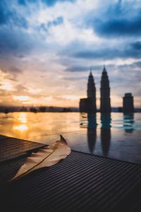 Scenic view of sea against buildings during sunset