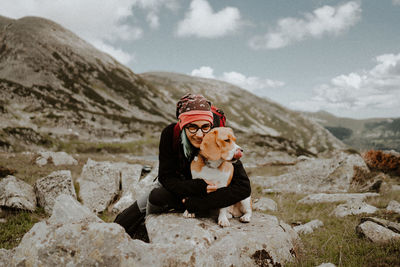 Dog sitting on mountain with his girlfriend