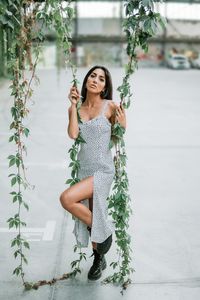 Full length portrait of young woman holding camera