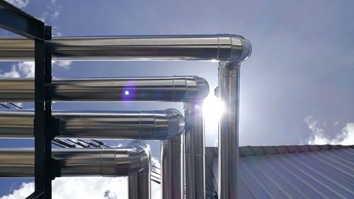 Low angle view of metallic structure against sky on sunny day