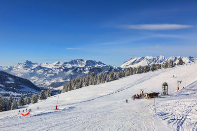 Scenic view of snowcapped mountains against blue sky