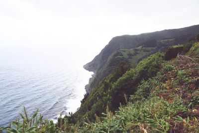 Scenic view of sea and mountains against clear sky