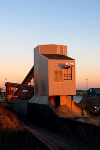 Factory against sky at sunset