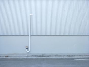 White wall with umbrella on street in background