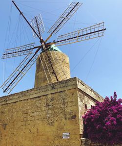 Low angle view of traditional windmill against sky