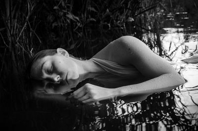 Close-up of young woman sleeping in pond