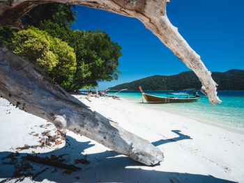 Koh ra wi island white sand beach, turquoise sea and long tail boat. near koh lipe island, thailand.