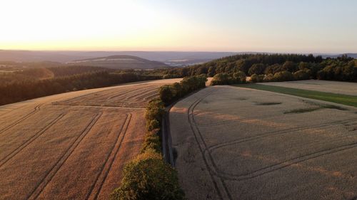 Road amidst field against sky