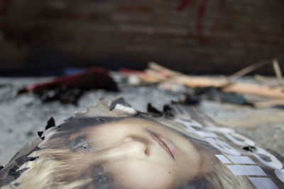 Close-up portrait of woman lying down on land