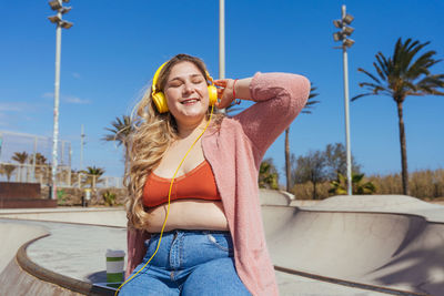 Young woman sitting in skateboard park