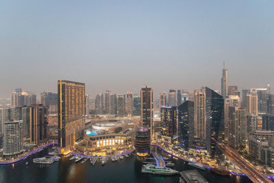 Illuminated buildings in city against clear sky . dubai . uae. 