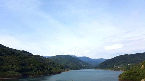 Scenic view of river amidst mountains against sky