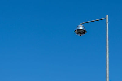 Low angle view of street light against blue sky