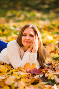 Portrait of young woman with autumn leaves