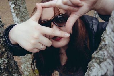 Close-up portrait of young woman with hands