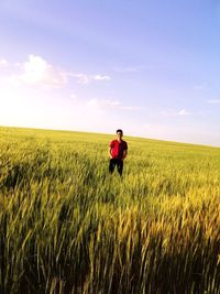 Mid distance of man standing on agricultural field against sky