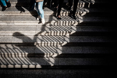 Low section of people walking on staircase in city