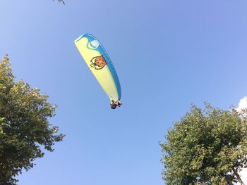 Low angle view of kite flying against clear blue sky