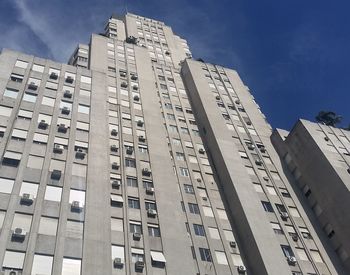 Low angle view of modern building against blue sky