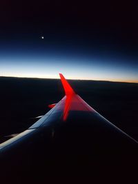 Airplane flying over landscape against blue sky