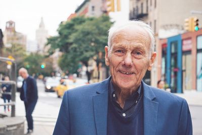 Portrait of smiling senior man in city