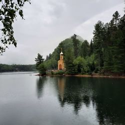 Scenic view of lake by building against sky