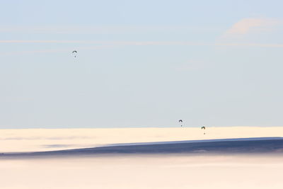 Scenic view of microlight / ultralight aircraft flying above the clouds over a foggy landscape