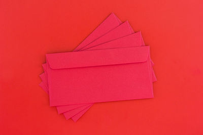 High angle view of pink paper against red background