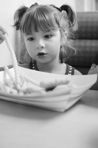 Cute girl having snacks at table