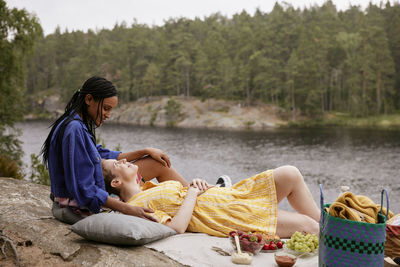 Female couple having picnic by river