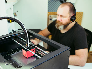 Adult man working with a project for 3d printer at home