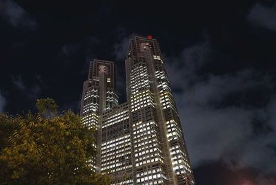 Low angle view of illuminated buildings against cloudy sky