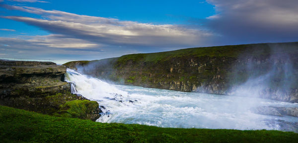 Scenic view of waterfall against sky