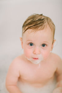 Closeup of baby in the bathtube with bubbles on face