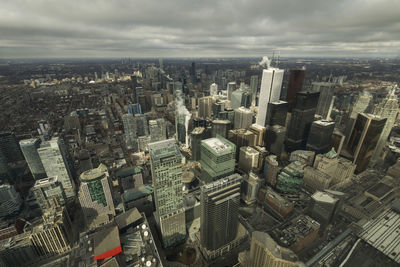 High angle view of city buildings against cloudy sky